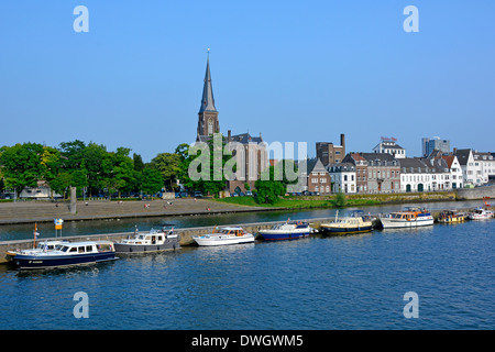 Maastricht River Meuse (maas) et long mur de quai séparant le canal principal de la voie navigable fournit des amarrages pour visiter les bateaux à moteur église de la flèche de l'UE Banque D'Images