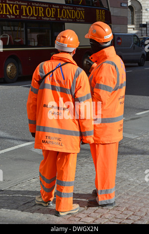 Deux marécages de circulation à haute visibilité en attente de superviser le déchargement de véhicules à l'extérieur du chantier de construction à Londres, Angleterre, Royaume-Uni Banque D'Images