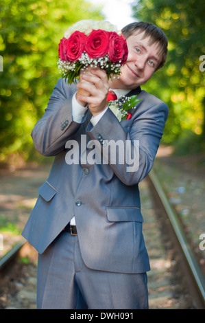 La belle jeune marié d'un bouquet de roses rouge et blanc sur une piste de l'été Banque D'Images