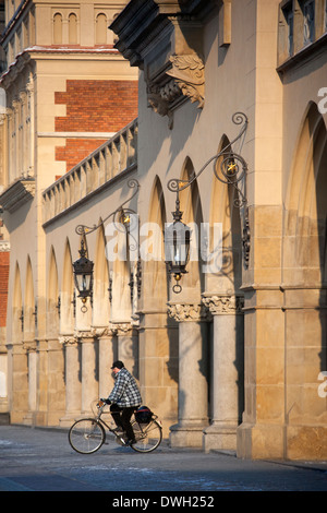 Un cycliste à travers la passerelle centrale du tissu située sur la Grand'Place (Rynek Glowny) dans la ville de Cracovie en Pologne Banque D'Images