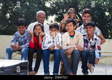 La famille conjoint Indien assis et regarder la télévision Banque D'Images