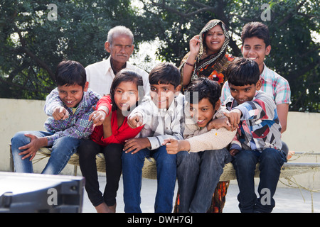 La famille conjoint Indien assis et regarder la télévision Banque D'Images