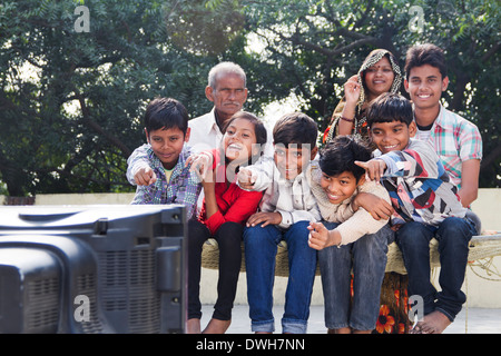 La famille conjoint Indien assis et regarder la télévision Banque D'Images