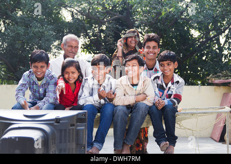 La famille conjoint Indien assis et regarder la télévision Banque D'Images