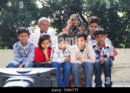 La famille conjoint Indien assis et regarder la télévision Banque D'Images