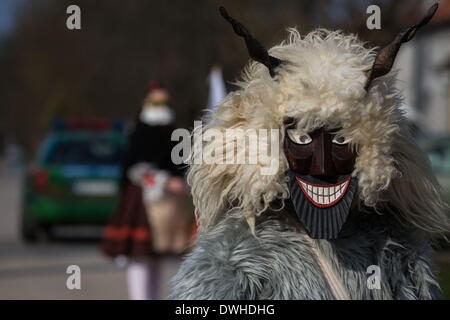 Mohacs (Hongrie). 4e Mar, 2014. Masque en bois traditionnel dans fullmetal avec une voiture de police dans l'arrière-plan. Les festivités à Mohacs Fullmetal dans le sud de la Hongrie sont un carnaval de six jours à la fin de février pour marquer la fin de l'hiver, nommé pour les Busos, effrayant les gens costumés (traditionnellement, les hommes) de porter des masques en bois et de grands manteaux laineux. © Zsolt Repasy/ZUMA/ZUMAPRESS.com/Alamy fil Live News Banque D'Images