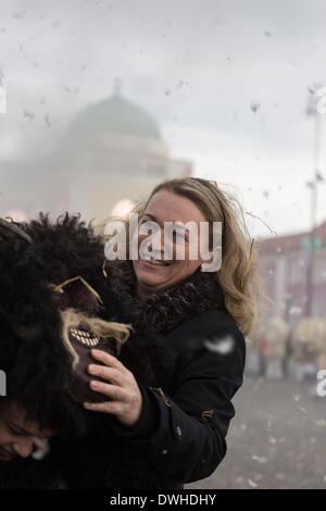 Mohacs (Hongrie). 4e Mar, 2014. Femme est la protection de son jeune fils du tir de canon. Busos sont canons tirant sur la place principale de Mohacs pour chasser l'hiver. La plupart des canons sont remplis avec de la laine et de la sciure. Les festivités à Mohacs Fullmetal dans le sud de la Hongrie sont un carnaval de six jours à la fin de février pour marquer la fin de l'hiver, nommé pour les Busos, effrayant les gens costumés (traditionnellement, les hommes) de porter des masques en bois et de grands manteaux laineux. © Zsolt Repasy/ZUMA/ZUMAPRESS.com/Alamy fil Live News Banque D'Images