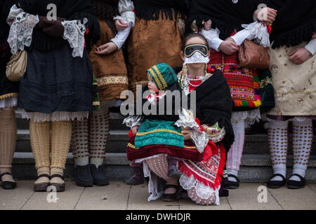 Mohacs (Hongrie). 4e Mar, 2014. Woman is holding sa jeune fille. Les deux sont vêtus de vêtements traditionnels sokac. Les festivités à Mohacs Fullmetal dans le sud de la Hongrie sont un carnaval de six jours à la fin de février pour marquer la fin de l'hiver, nommé pour les Busos, effrayant les gens costumés (traditionnellement, les hommes) de porter des masques en bois et de grands manteaux laineux. © Zsolt Repasy/ZUMA/ZUMAPRESS.com/Alamy fil Live News Banque D'Images
