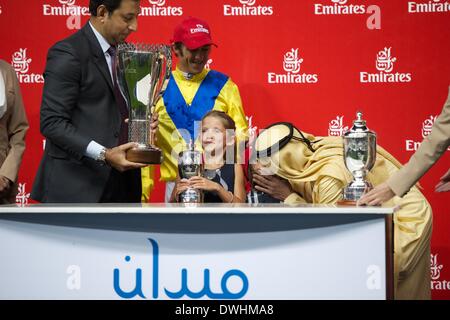 Dubaï, Émirats arabes unis. 8 mars, 2014. Cheikh Mohammed Bin Khalifa Al Maktoum embrasse les enfants de jockey Christophe Soumillon après leur victoire dans la course de Jebel Hatta Crédit : Tom Morgan/Alamy Live News Banque D'Images