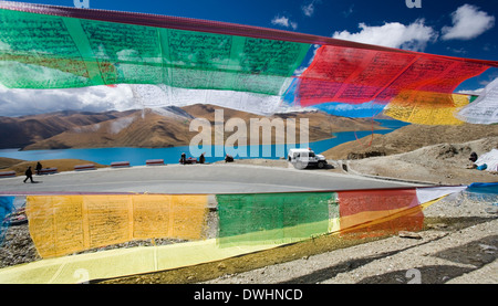 Les drapeaux de prière et le passe-haut Yamdrok Lac Turquoise (16860ft) sur le plateau tibétain au Tibet. Banque D'Images