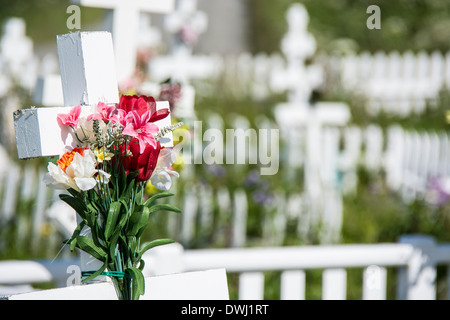 Bouquet de fleurs sur une croix orthodoxe russe dans le cimetière de Holy Transfiguration du Seigneur Église, Ninilchik, Alaska Banque D'Images