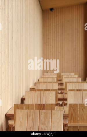 Centre de la nature finlandaise Haltia, Espoo, Finlande. Architecte : Lahdelma & Mahlamäki, 2013. Détail de tables et de chaises en bois et de mur Banque D'Images