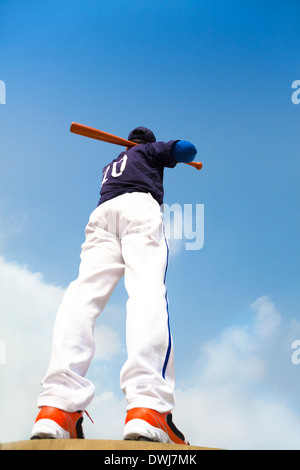 La tenue d'un joueur de baseball bat avec ciel bleu piscine Banque D'Images