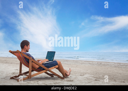 Businessman working with computer sur la plage Banque D'Images
