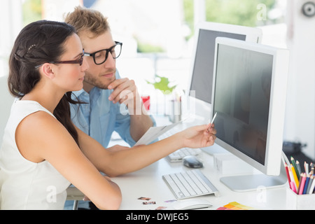 Partenaires créatifs travaillant sur ordinateur à leur bureau Banque D'Images