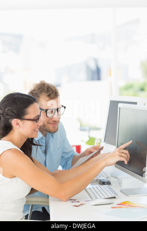 Partenaires créatifs travaillant ensemble sur ordinateur à leur bureau Banque D'Images