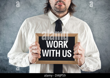 Businessman holding blackboard with TRAVAILLER AVEC NOUS titre. Concept d'entreprise. Banque D'Images