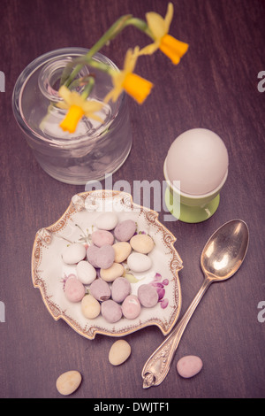 L'installation de pâques avec une tasse, narcisses et sucreries Banque D'Images