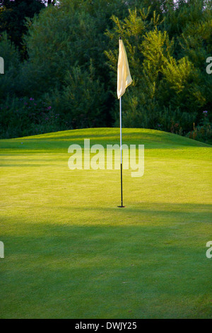 Drapeau de golf dans le trou sur le vert sur un terrain de golf. Banque D'Images