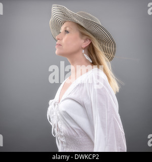 Belle femme mature portant chemise d'été et hat, studio shot Banque D'Images