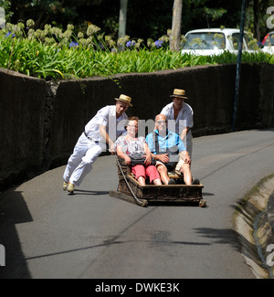 Madère Portugal Monte,un couple heureux profiter de la luge en bas de la colline pour Funchal Banque D'Images