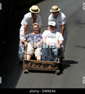 Madère Portugal Monte,un couple heureux profiter de la luge en bas de la colline pour Funchal Banque D'Images