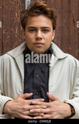 Souriant d'un beau jeune homme de race blanche assise sur un quai de chargement industriel vintage Banque D'Images