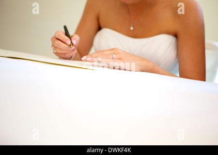 Mariée signature document juridique après le mariage Banque D'Images