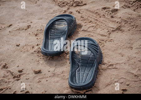 Sandales noires sur la plage de Gandia, Espagne Banque D'Images