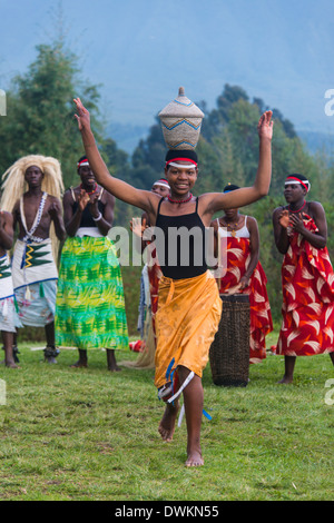 Femme portant un panier sur la tête lors d'une cérémonie d'anciens braconniers, dans le parc national des Virunga, le Rwanda, l'Afrique Banque D'Images