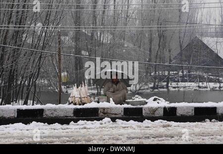 Srinagar, au Cachemire sous contrôle indien. Mar 11, 2014. Un homme vend des légumes au milieu du Cachemire de neige à Srinagar, capitale d'été du Cachemire sous contrôle indien, le 11 mars 2014. Le Cachemire sous contrôle indien témoin d'une neige fraîche qui a fermé l'autoroute nationale Srinagar-Jammu, la seule route qui relie la région du Cachemire avec le reste de l'Inde. Département météorologique prédit plus de neige dans la région. Credit : Javed Dar/Xinhua/Alamy Live News Banque D'Images