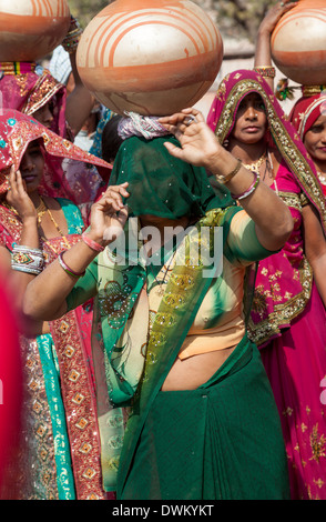 Le Rajasthan, Inde. La danse des femmes avec des pots sur la tête lors d'une célébration de mariage. Banque D'Images