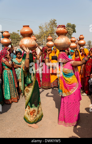 Le Rajasthan, Inde. La danse des femmes avec des pots sur la tête lors d'une célébration de mariage. Banque D'Images