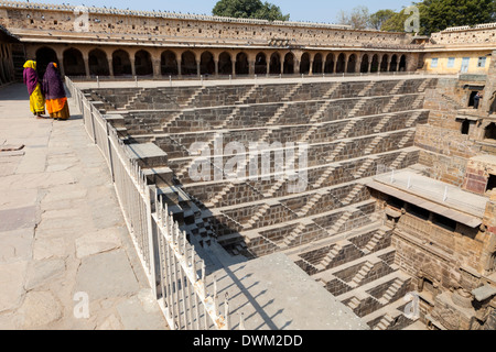 Deux femmes regardant la Chand Baori Abhaneri étape bien, Village, Rajasthan, Inde. Construit 800-900A.D. Banque D'Images