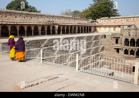 Deux femmes regardant la Chand Baori Abhaneri étape bien, Village, Rajasthan, Inde. Construit 800-900A.D. Banque D'Images