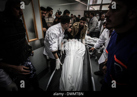 Gaza, Territoires palestiniens. Mar 11, 2014. Vérifier les médecins palestiniens enveloppé corps de trois militants tués à partir de l'aile armée du Jihad islamique, les Brigades Al-qods, à la morgue de l'hôpital avant leur inhumation à Khan Yunis après une frappe aérienne israélienne dans le sud de la bande de Gaza, le 11 mars 2014. Une frappe aérienne israélienne a tué les trois militants du Hamas du territoire, a déclaré le ministère de la santé. /ZUMAPRESS.com/Alamy NurPhoto Crédit : Live News Banque D'Images