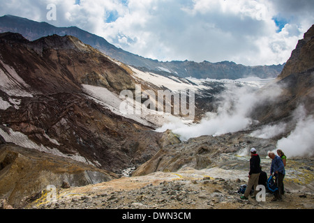 Les touristes debout près de fumeurs sur les fumerolles du volcan Mutnovsky, du Kamtchatka, la Russie, l'Eurasie Banque D'Images