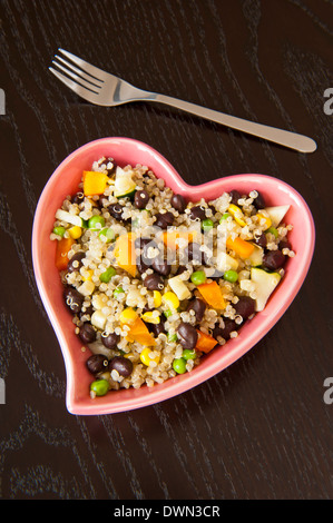 Plat en forme de coeur rose de quinoa et de légumes grillés Banque D'Images