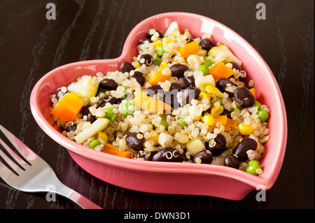 Plat en forme de coeur rose de quinoa et de légumes grillés Banque D'Images