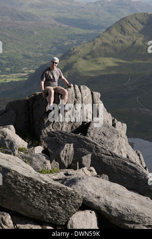 Un randonneur en appui sur un affleurement rocheux près de Glyder Fach dans la chaîne de montagnes de Snowdonia au Pays de Galles. Banque D'Images