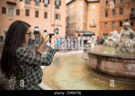 Jeune femme à prendre des photos avec un téléphone mobile, la Piazza Navona, Rome, Latium, Italie, Europe Banque D'Images