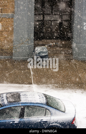 A New York City's Mailman chariot en face d'un immeuble que la neige s'accumuler sur le trottoir et des voitures en stationnement Banque D'Images