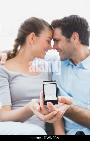 Aimé jusqu'jeune couple avoir engagé sur le canapé Banque D'Images