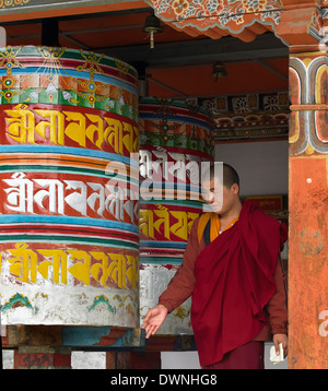 Un moine bhoutanais avec de grandes roues de prière à Paro Dzong dans le Royaume du Bhoutan. Banque D'Images