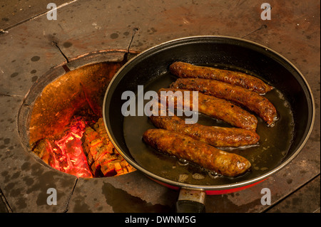 Les saucisses à la poêle dans une casserole sur un vieux poêle à bois, Middle Franconia, Bavaria, Germany. Banque D'Images