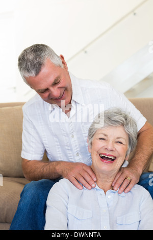 Homme donnant à ses hauts femme une épaule rub qui est smiling at camera Banque D'Images