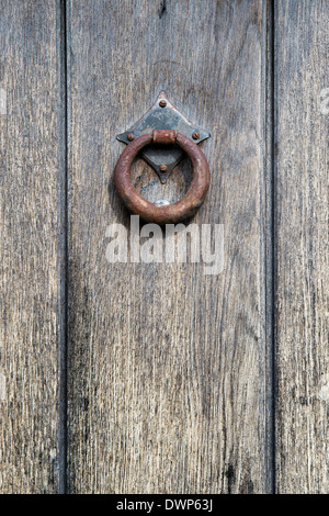 Heurtoir de porte en fer forgé rouillé sur une vieille porte en chêne en bois dans la région des Cotswolds, en Angleterre Banque D'Images