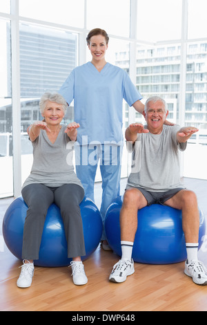 Female therapist aider senior couple avec des exercices Banque D'Images