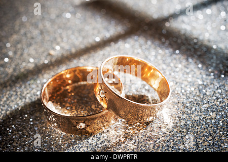 Anneaux de mariage d'or sur le fond argenté Banque D'Images