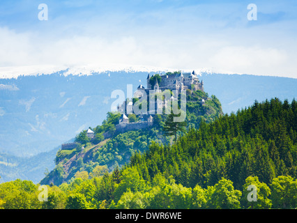 Château Hochosterwitz en Autriche derrière la forêt et montagnes enneigées avant Banque D'Images